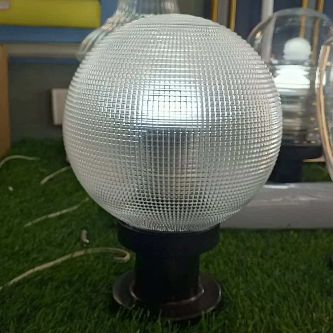Globe-shaped outdoor lamp on a black metal base